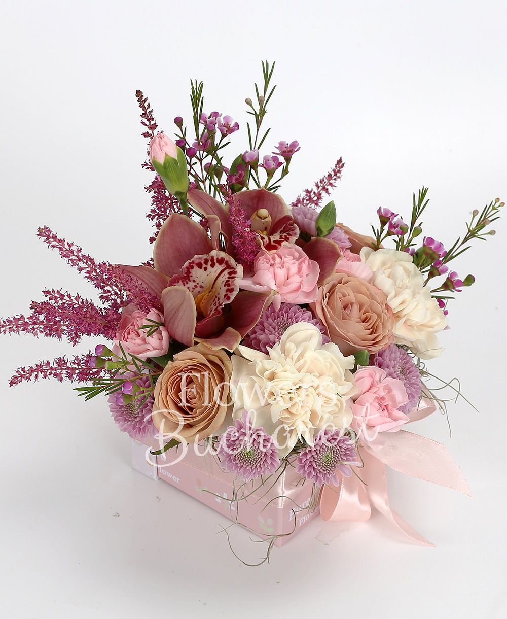 3 cappuccino roses, 3 cream carnations, 3 pink carnations, 3 purple santini, 1 pink waxflower, 3 red astilbe, garnet cymbidium, greenery