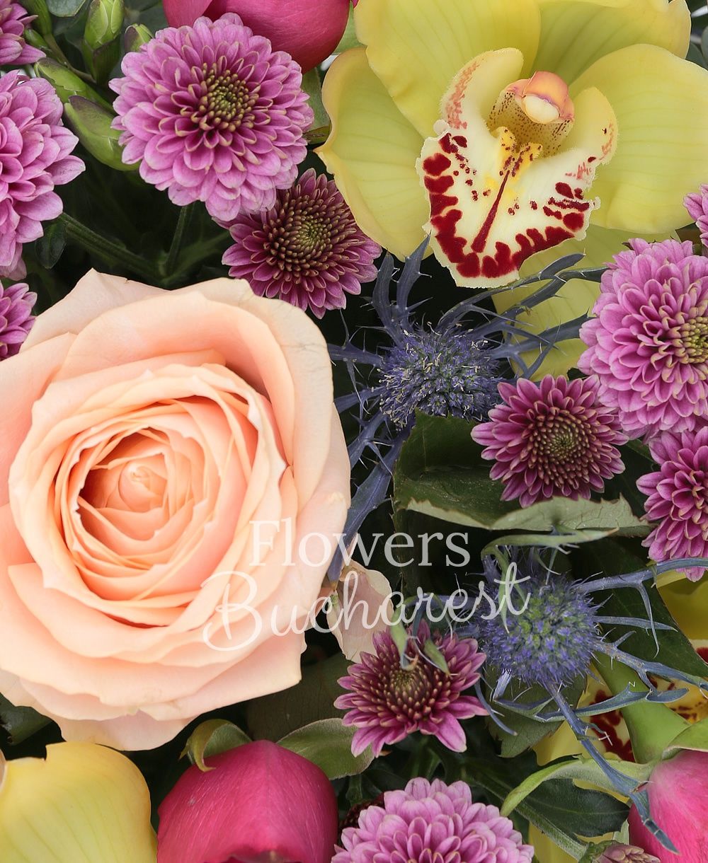 3 peach roses, 5 cyclam roses, 3 pink santini, 3 blue eryngium, yellow cymbidium, greenery