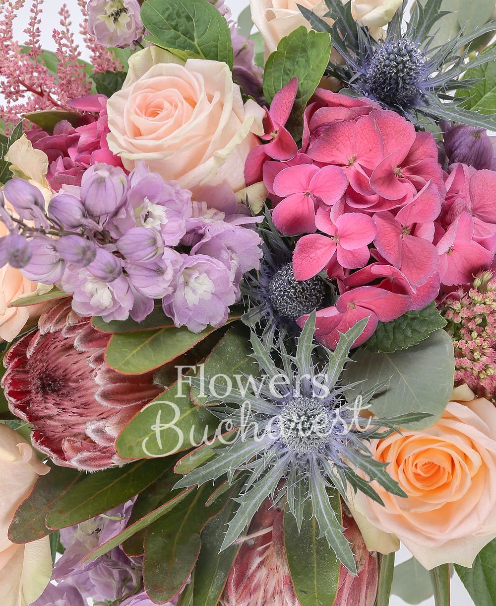 5 cream roses, 2 proteea, 3 purple delphinium, 2 astilbe, 2 eryngium, 2 hydrangeas, greenery