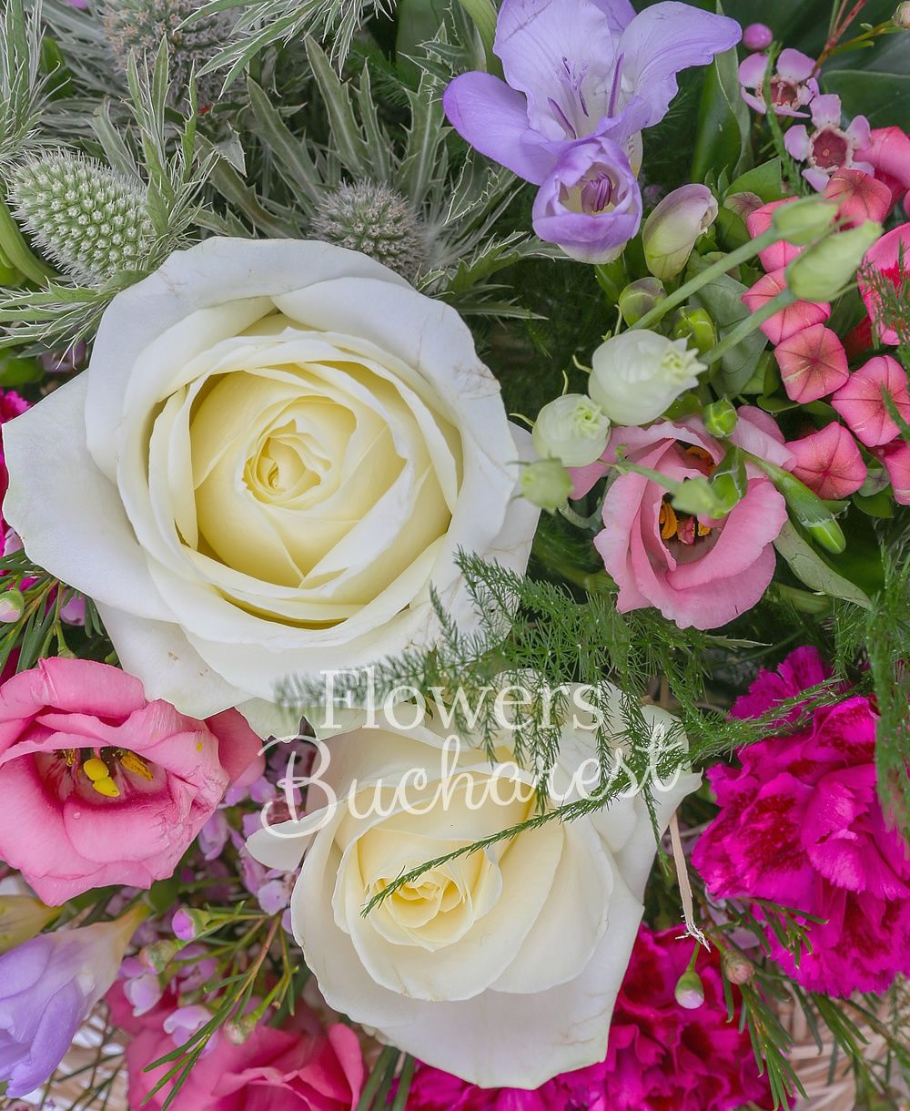 3 white roses, 5 pink lisianthus, 3 white eryngium, 5 purple freesias, 3 cyclam carnations, 3 pink bouvardia, waxflower, greenery